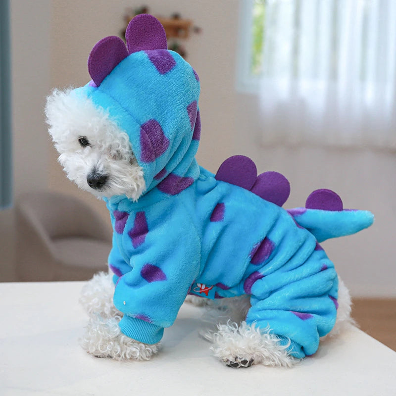 A blue plush fleece pet overal dog or cat with purple accents sitting on a white surface.