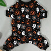Black long-sleeved dog pajamas with an orange pumpkin and spiderweb Halloween print