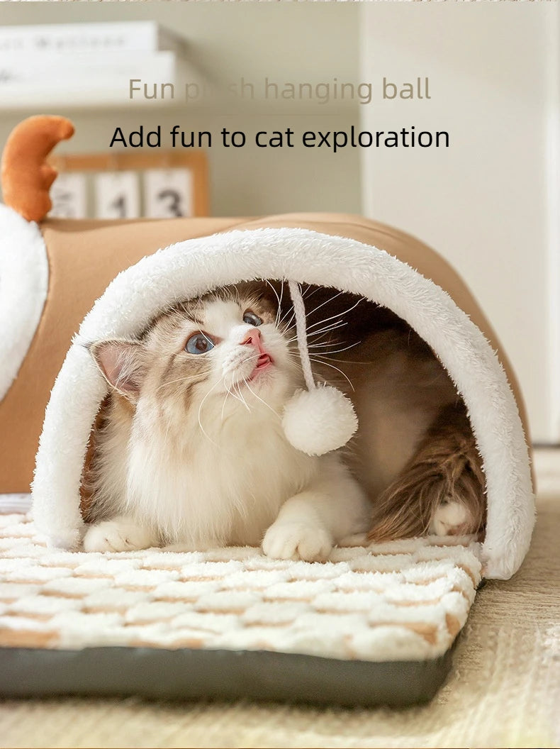 A fluffy tabby kitten peeks out of a white plush reindeer tunnel cat bed.