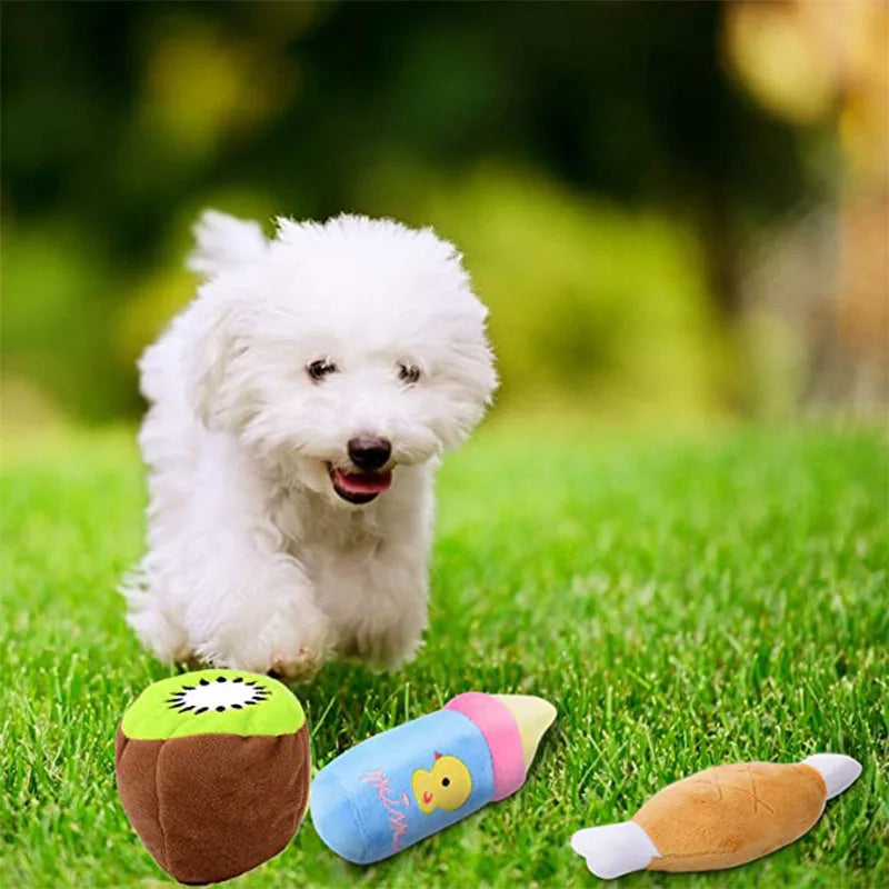 A white bone-shaped squeaky plush dog toy resting on green grass.