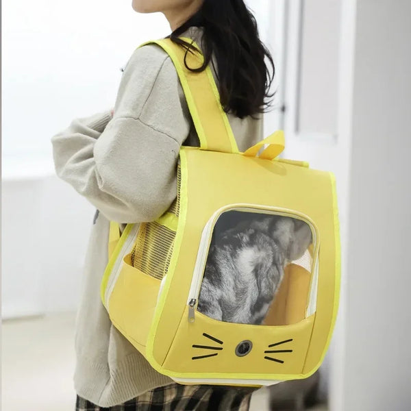 A person is holding a yellow breathable pet carrier backpack designed for cats and small dogs.