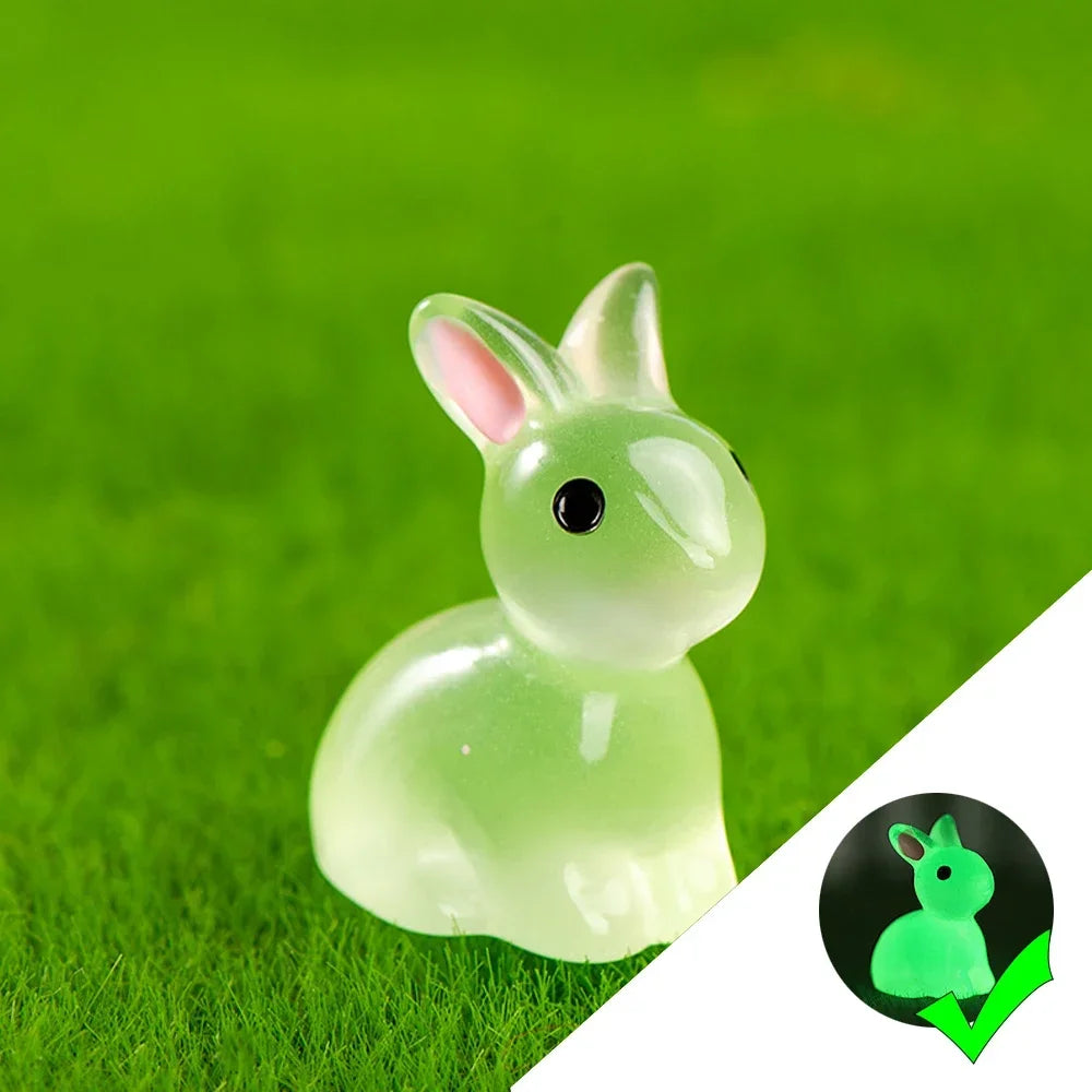 A small, translucent green resin bunny figurine resting on bright green grass.