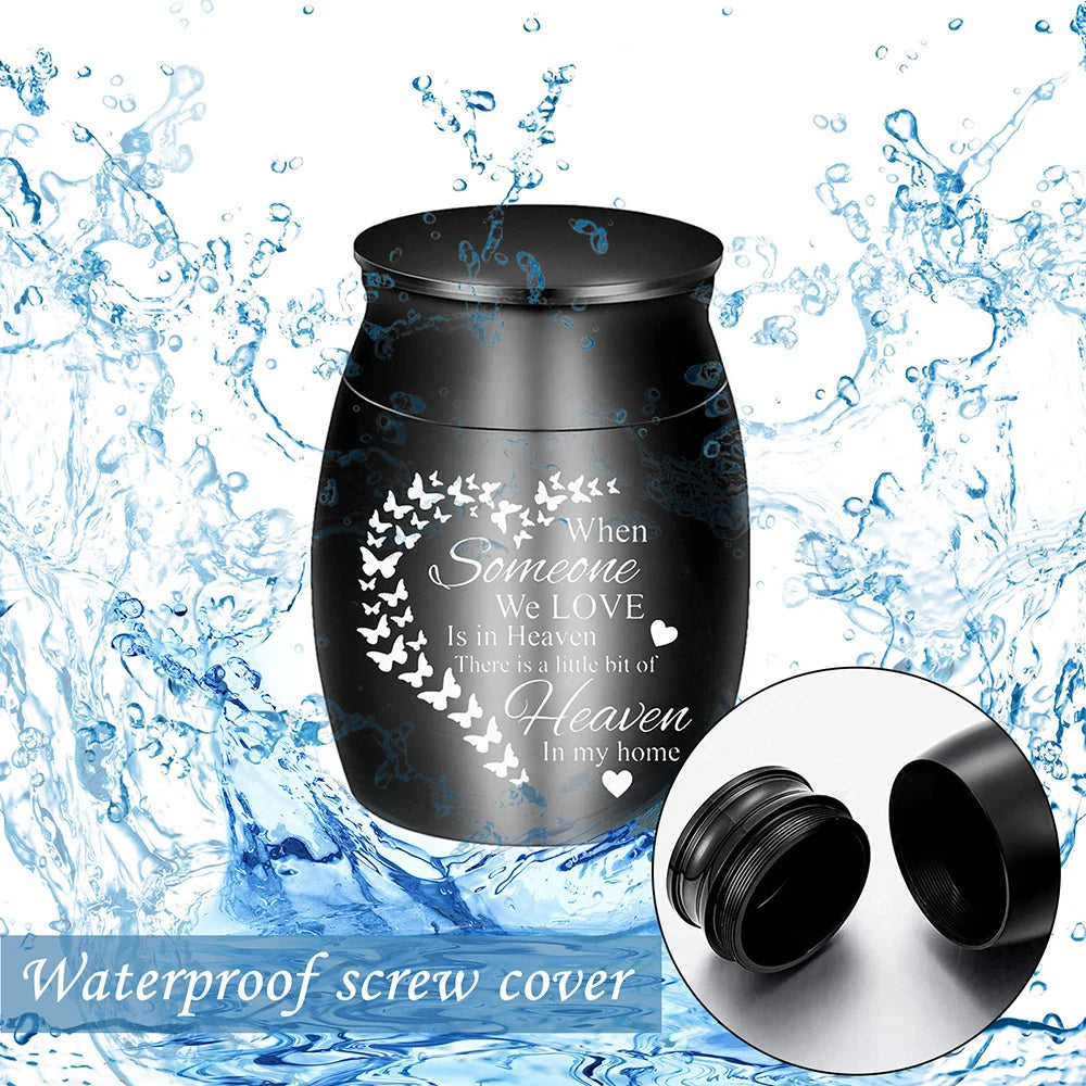 Schwarzes Aluminium-Herz-Schmetterlings-Andenken-Urn, umgeben von aufschäumendem Wasser.