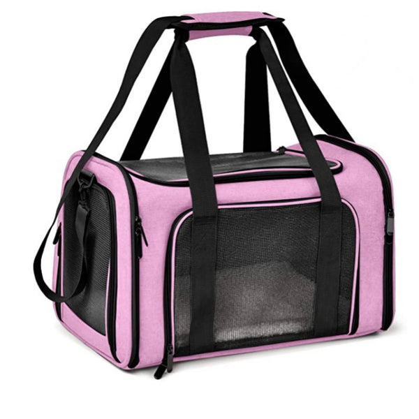 A pink soft-sided pet carrier for cats and small dogs with black handles and mesh window.