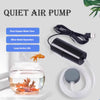 A black USB air pump for aquariums with a clear glass tank and tubing visible.