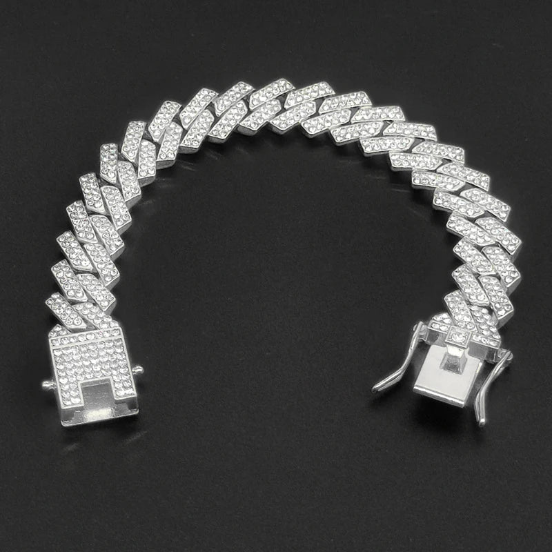 Collier Cuban link argenté avec diamants pavés sur fond noir.