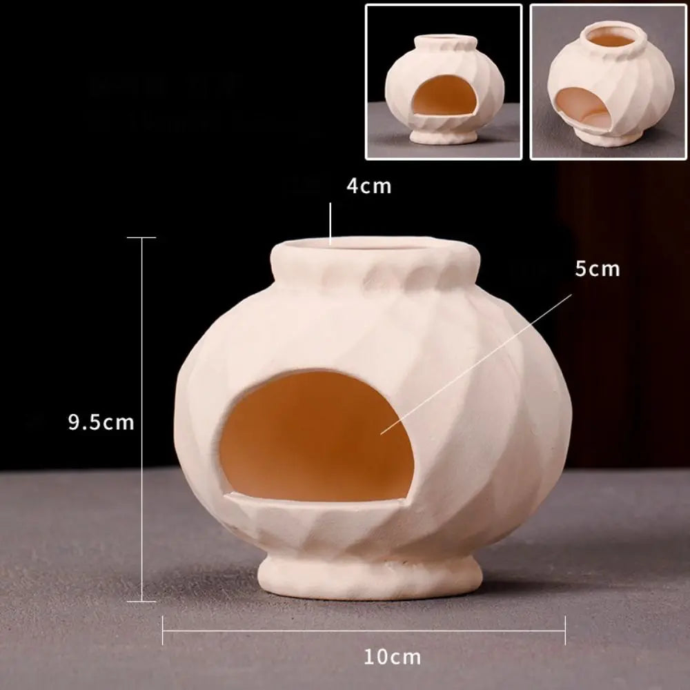 A white ceramic aquarium shrimp hideaway cave with a rounded body and an oval opening.