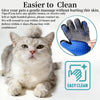 A fluffy gray cat is looking at a blue pet massage glove with a textured surface.