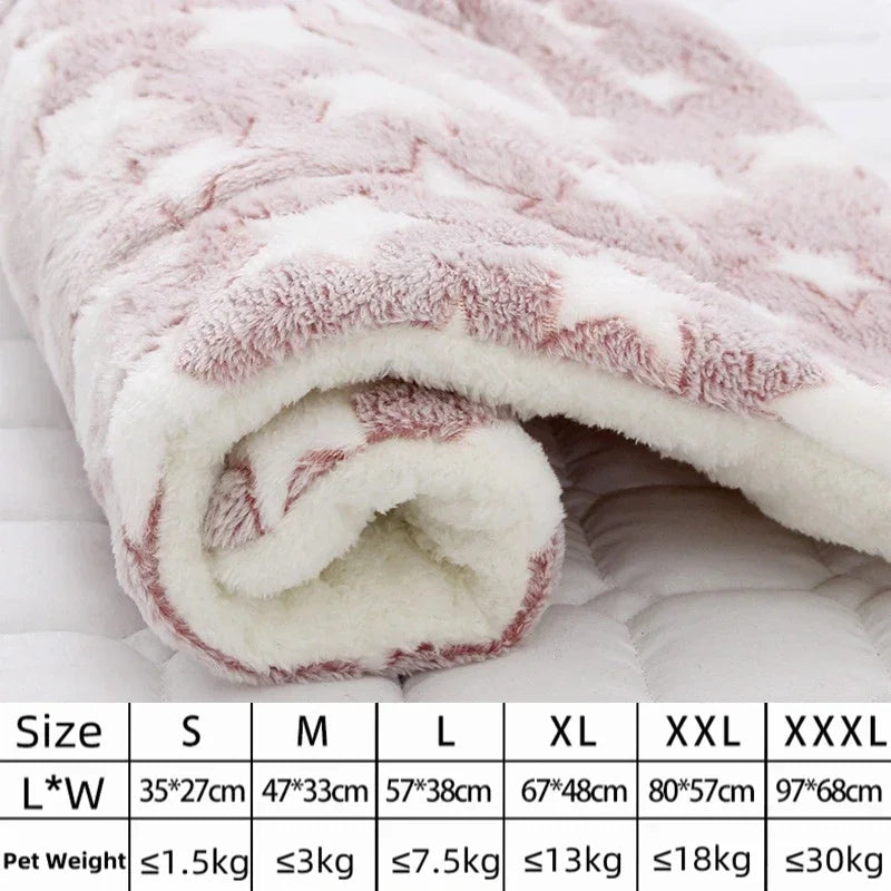 Un lit pour animal en flanelle rose et blanc, moelleux et roulé, avec différentes tailles présentées sur une surface blanche.