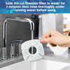 A hand is rinsing a white cat fountain filter piece under running water in a kitchen sink.