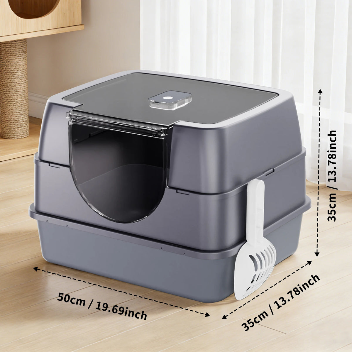A gray enclosed stainless steel cat litter box with a removable lid and a scoop shown on a wooden floor.