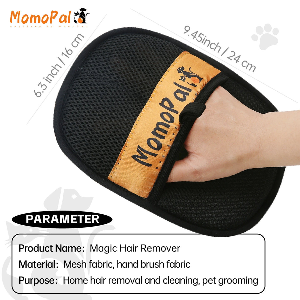 A hand is holding a black pet grooming mitt with an orange strap, designed for hair removal and cleaning.