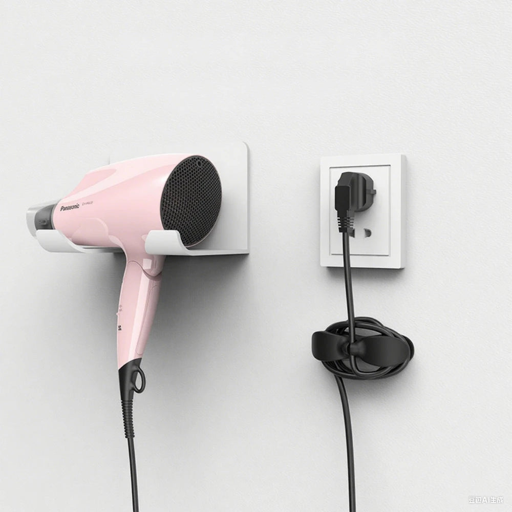 A pink hair dryer is mounted on a wall, with its cord hanging down. A silicone cable organizer is visible below.