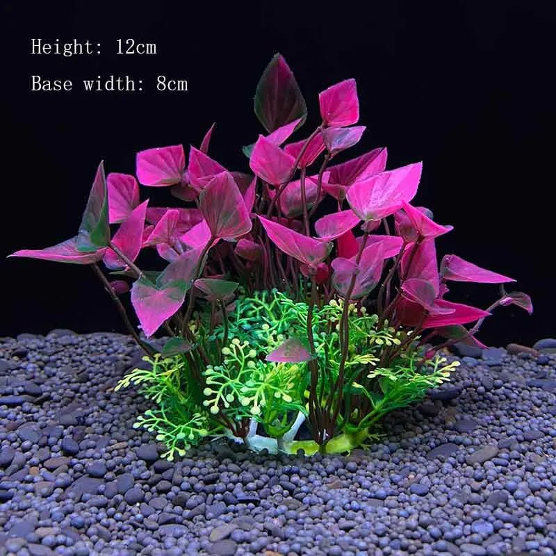 A vibrant artificial aquarium plant with magenta leaves and green foliage planted in dark gravel.