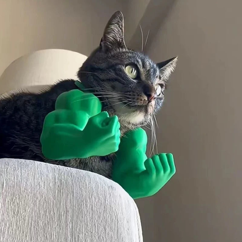 A domestic cat is holding a bright green 3D printed muscle arm accessory.