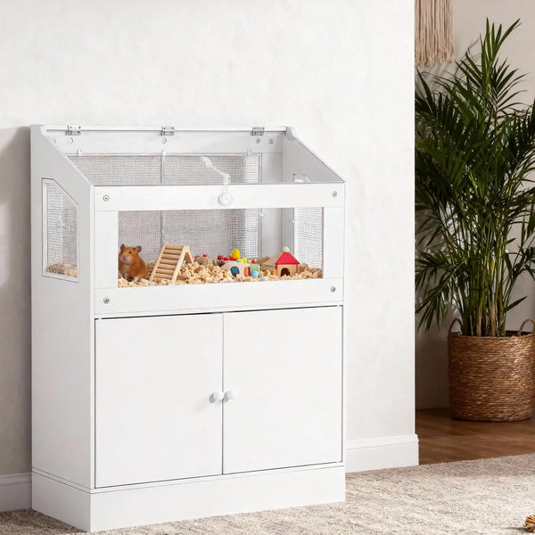 Un habitat pour animaux en acrylique blanc avec une enceinte transparente et un meuble de rangement sur un plancher en bois.