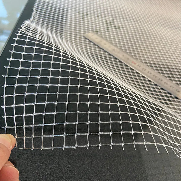 A transparent aquarium safety net is shown stretched over a surface, with a ruler visible for scale.