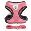 Pink pet harness and leash set with a white paw print design