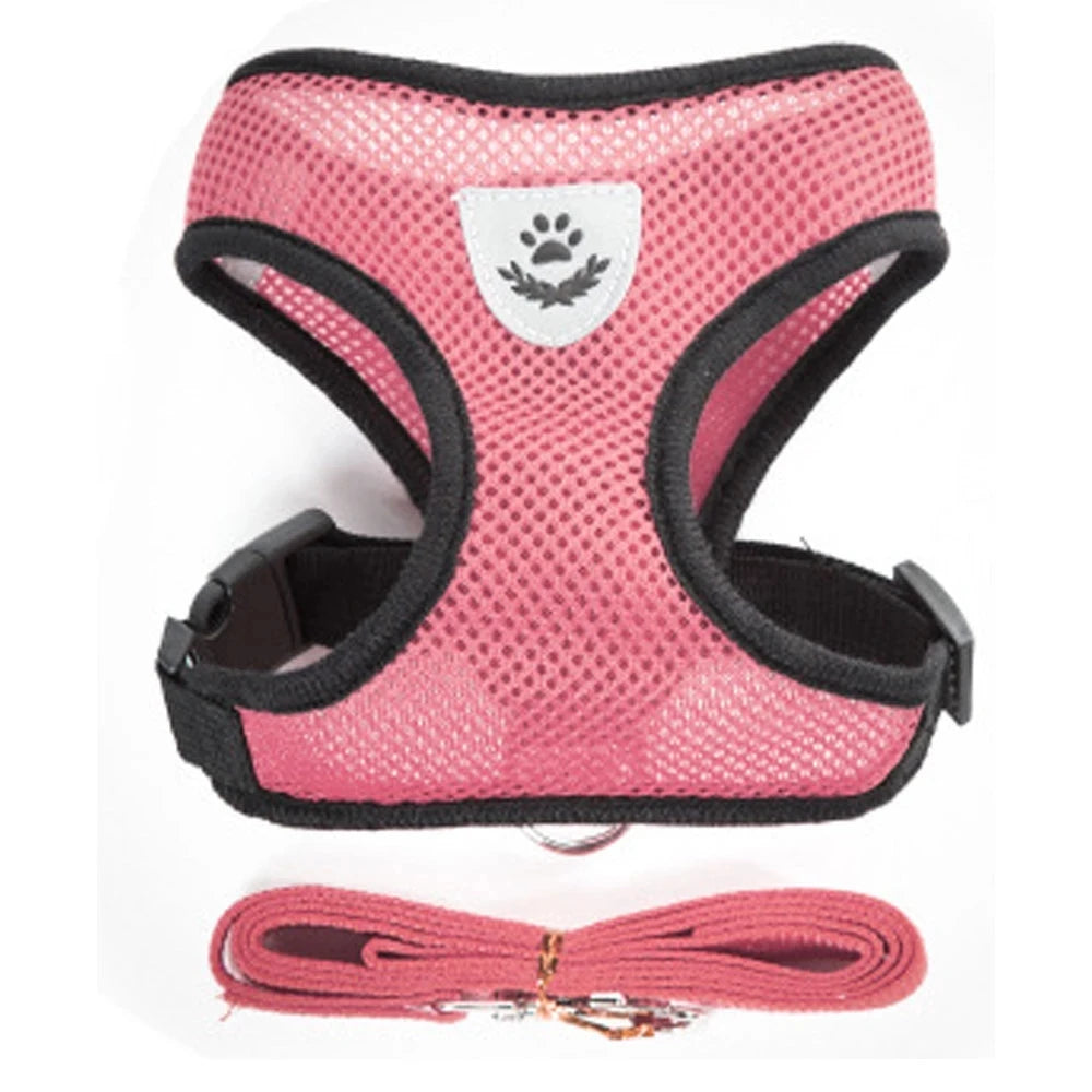 Pink pet harness and leash set with a white paw print design