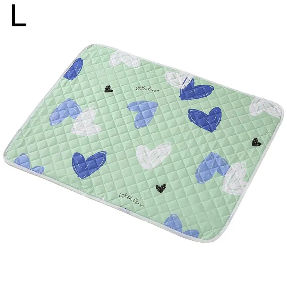 A light green quilted pet urine pad featuring small blue and white heart shapes.