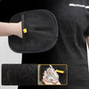 A hand is holding a black pet hair removal grooming glove, showing the texture of the glove and some pet hair.