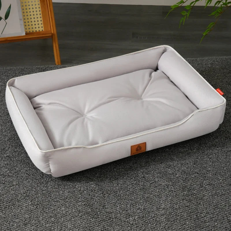 A white faux fleece pet sofa bed with a waterproof base lying on a gray carpet.