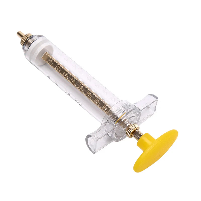 A clear plastic parrot feeding syringe with a soft yellow hose and a metal tip.