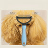 A blue stainless steel pet detangling comb is shown being used on a golden-colored dog's fur.