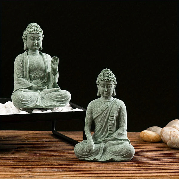A small, seated Buddha stone statue with a serene expression, resting on a wooden surface.