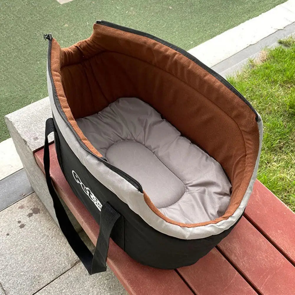 Transport pour animaux souple brun et gris avec rembourrage ajustable sur une surface en bois.