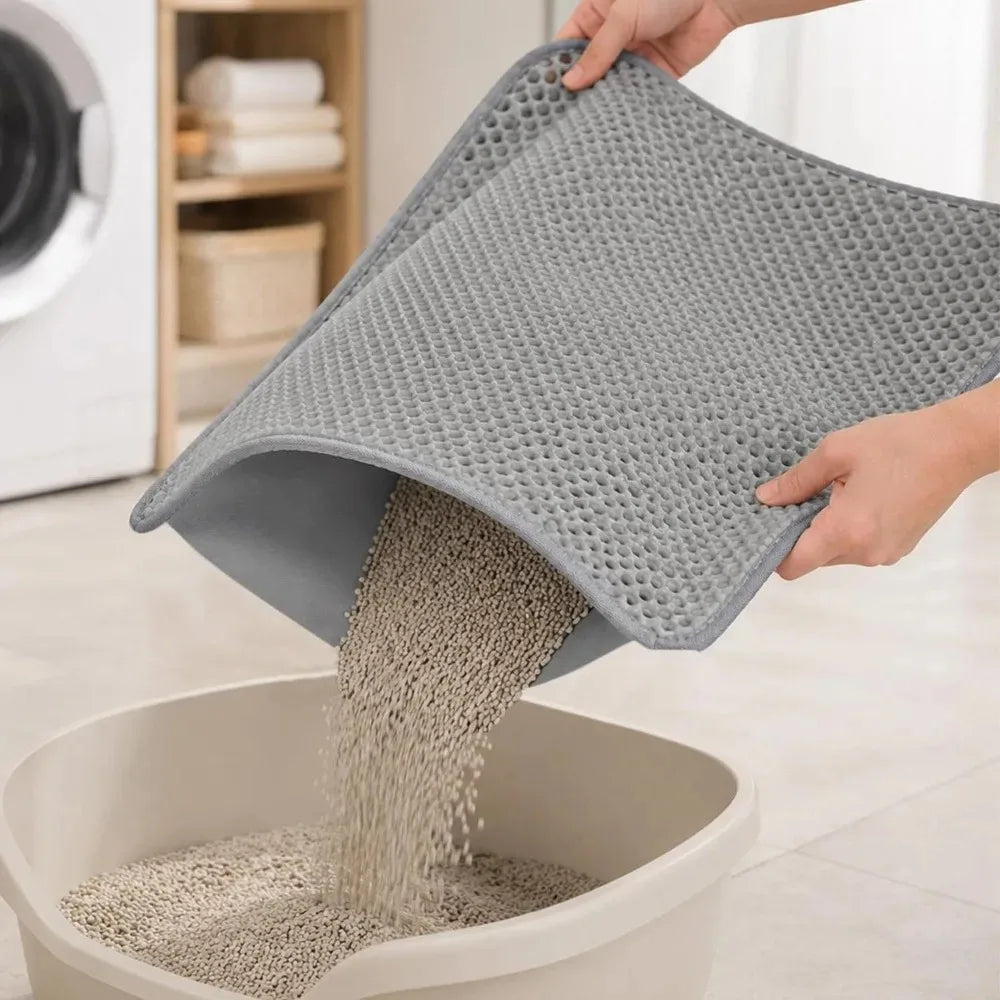 A hand is pouring light gray cat litter from an extra large double-layer mat into a white bowl.