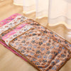 A stack of cozy flannel fleece pet blankets featuring a paw print design in shades of pink, beige, and brown.