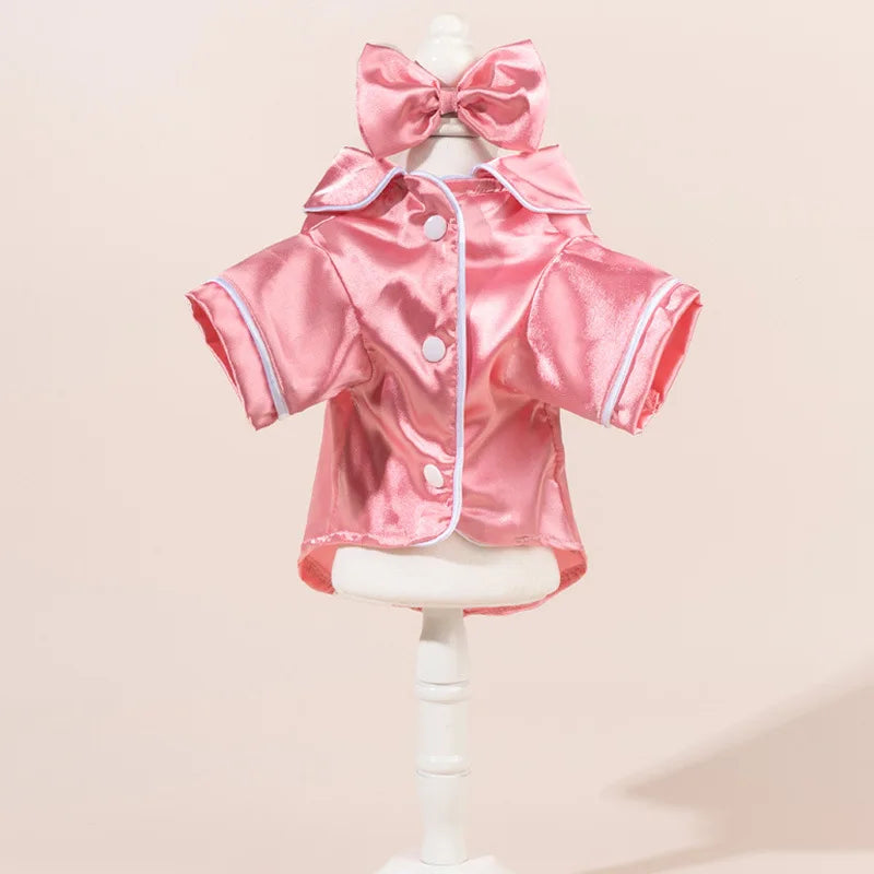 Rosa Satin-Hundpyjama-Set mit passender Schleife und Haarband auf einem Mannequin.