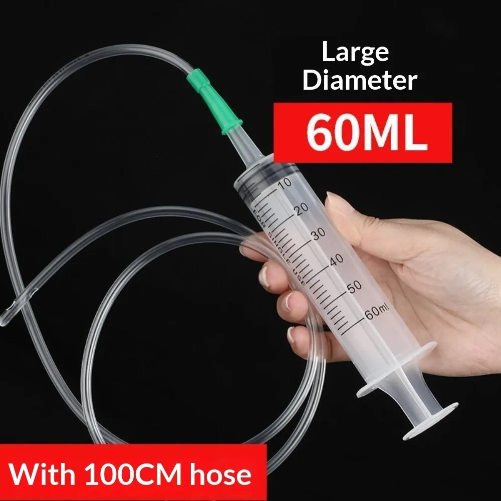 Eine Hand hält eine große 60ml Kunststoff-Spritze mit einer 100cm Schlauch für die Ölextraktion.
