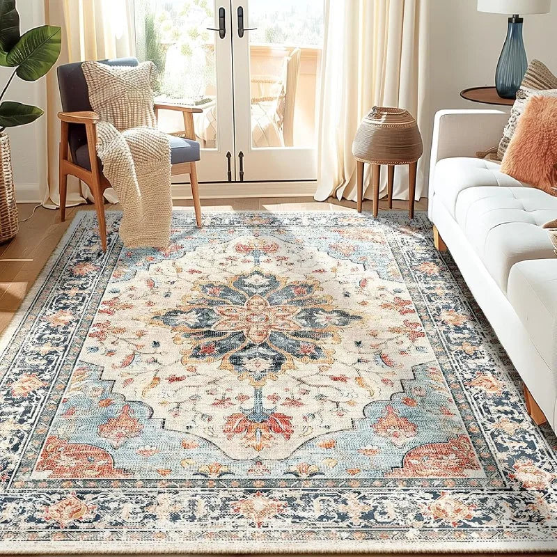 A detailed view of a blue and cream bohemian Persian floral area rug in a living room setting.