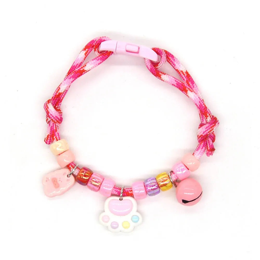 A colorful braided pet collar with a pink bell for cats and small dogs.