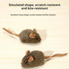 Une petite souris en plastique grise avec de grandes oreilles et une longue queue sur une surface en bois.