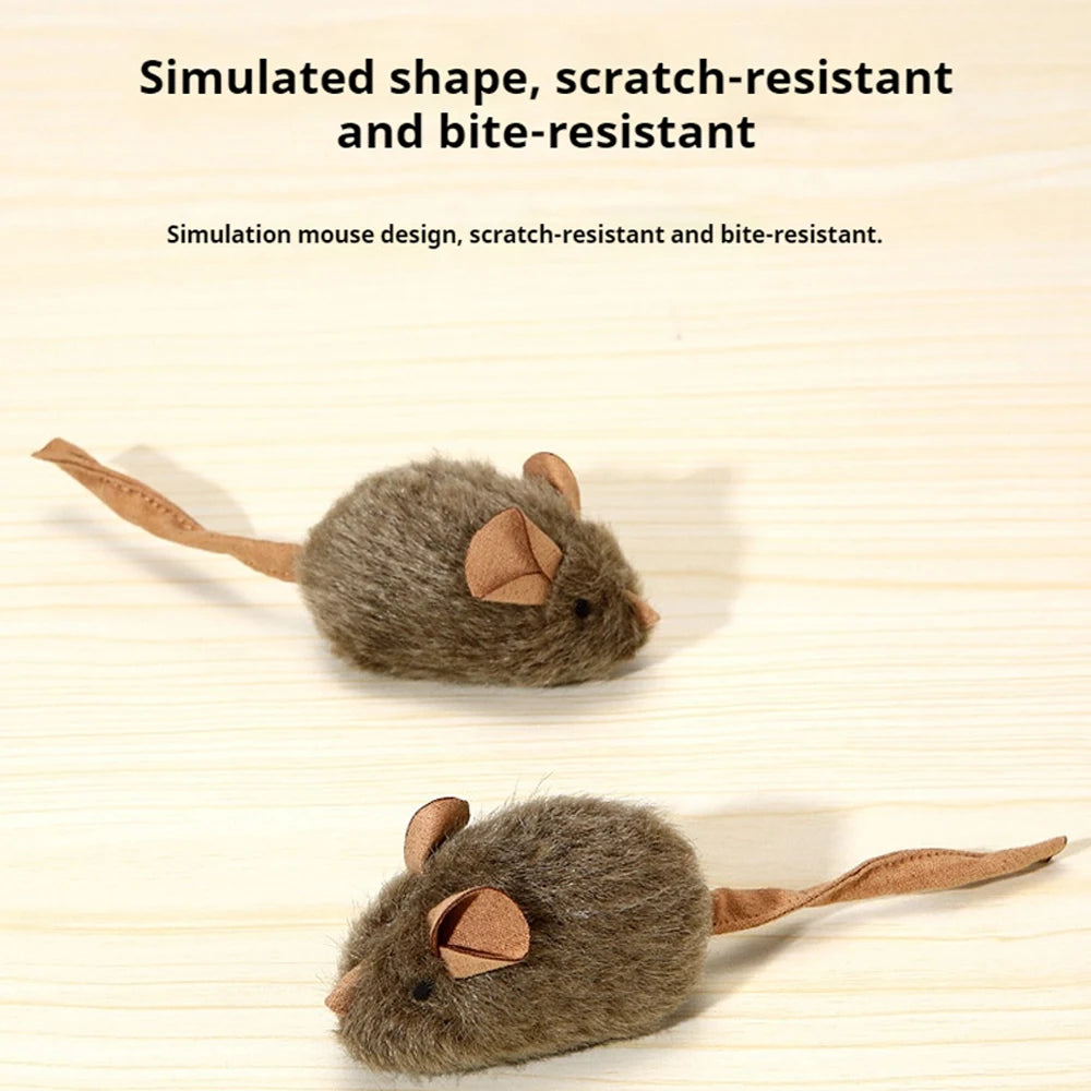 Une petite souris en plastique grise avec de grandes oreilles et une longue queue sur une surface en bois.