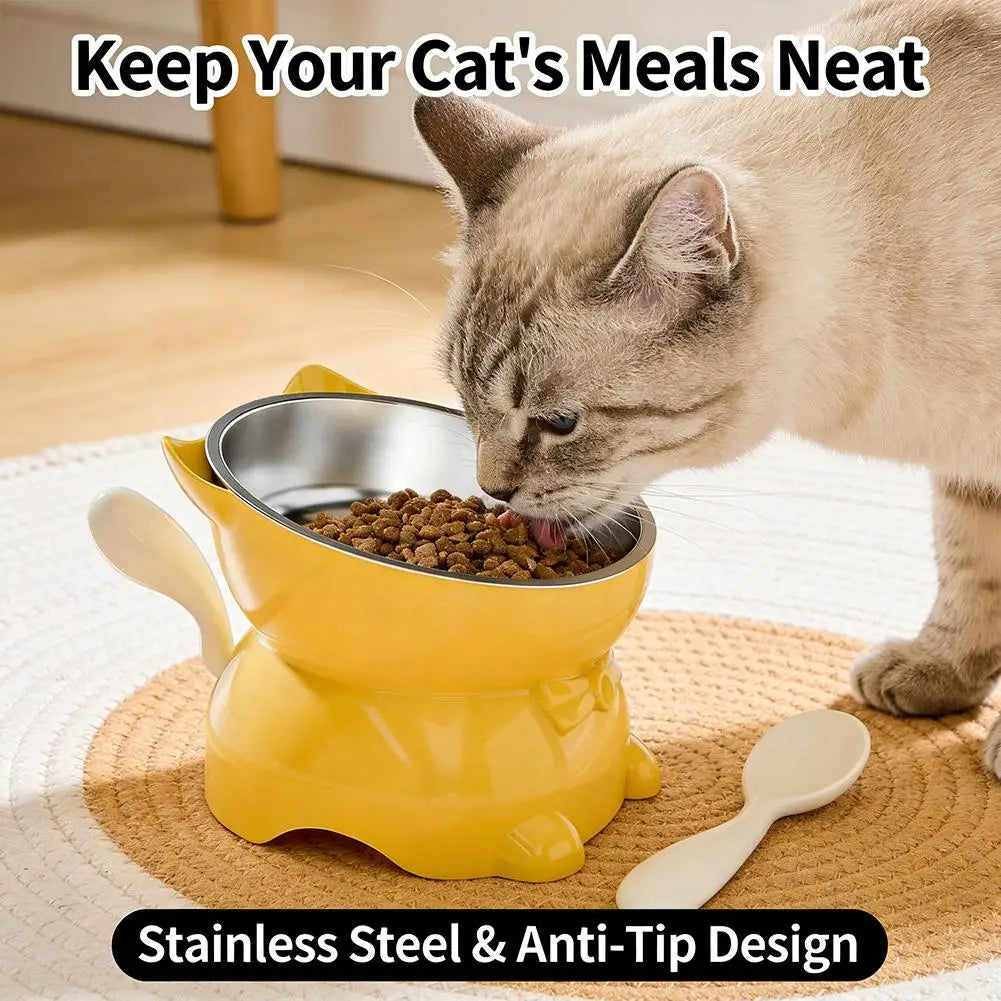 A cat is eating from a yellow elevated bowl with a stainless steel insert on a woven mat.