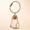 A clear glass cat charm keychain with a gold-colored leather cord and a small metal loop.