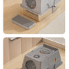 A gray fully enclosed stainless steel cat litter box with a flip-top lid and a separate grate shown on a wooden floor.