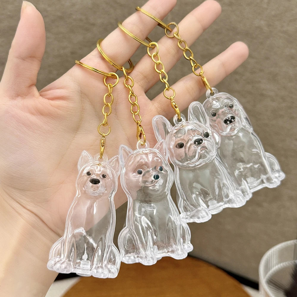 Clear glass puppy-shaped pet hair keepsake keychains being held in a hand