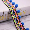 Close-up of a black and multicolored pearl pom pom fringe lace trim for sewing and DIY crafts