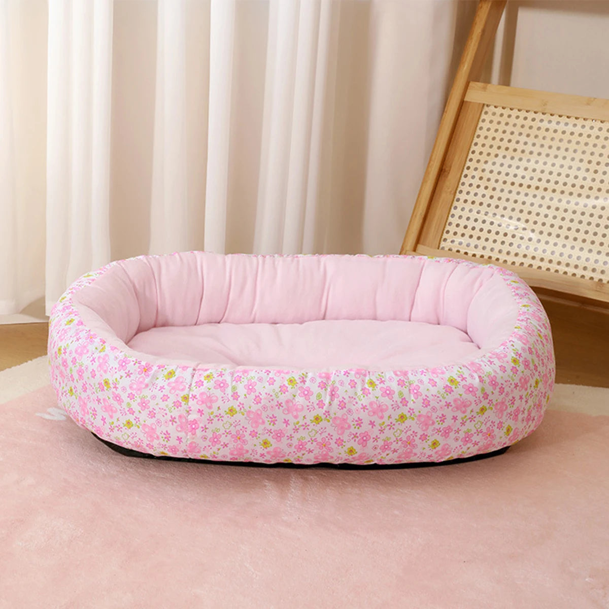 Pink floral pet bed for small dogs and cats resting on a pink rug.
