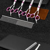 A set of professional stainless steel pet grooming scissors and a comb resting on a black surface.