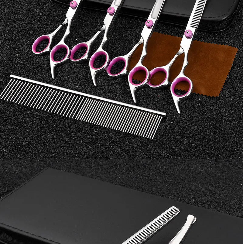 A set of professional stainless steel pet grooming scissors and a comb resting on a black surface.