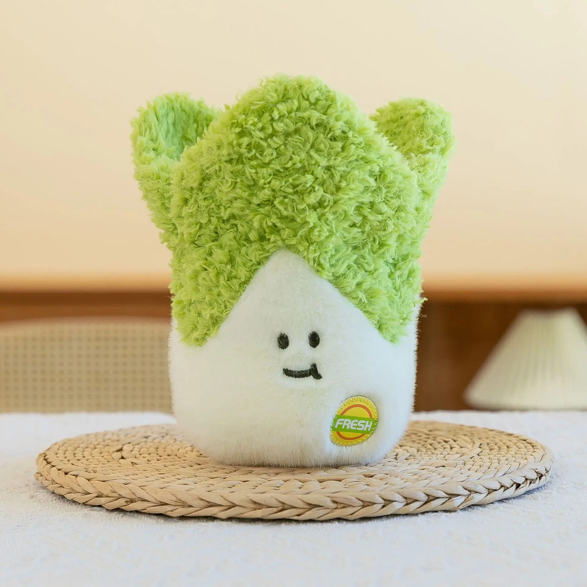 A soft plush vegetable doll featuring a white body and bright green fuzzy leaves, resting on a woven mat.