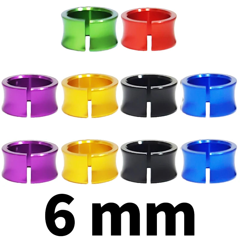 Six different colored metal bird identification rings shown in various shades of green, red, purple, yellow, black, and blue.