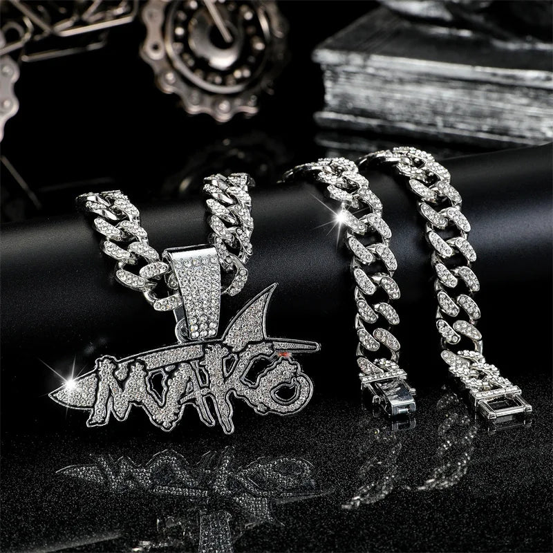 Silver iced out letter and animal pendant Cuban link chain necklace displayed on a black surface