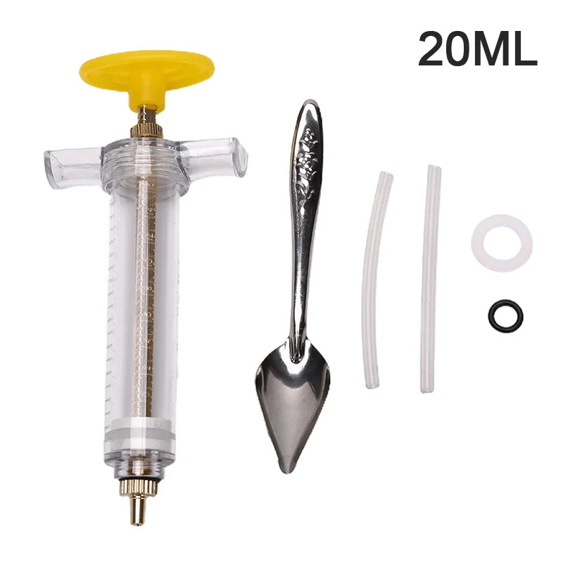 A clear plastic syringe with a yellow plunger and a metal feeding needle and soft hose for parrot feeding